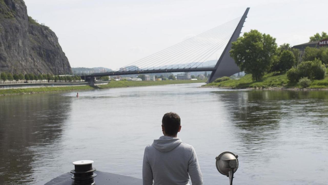 Michael Obert - von hinten zu sehen auf einem Schiff, vor ihm eine Brücke - unterwegs auf die Elbe