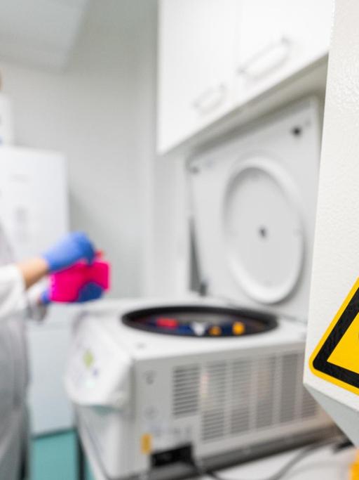 Ein Laborant bestückt eine Zentrifuge im Institut für Virologie an der Charité Berlin Mitte, in dem Untersuchungen zum Corona-Virus laufen.