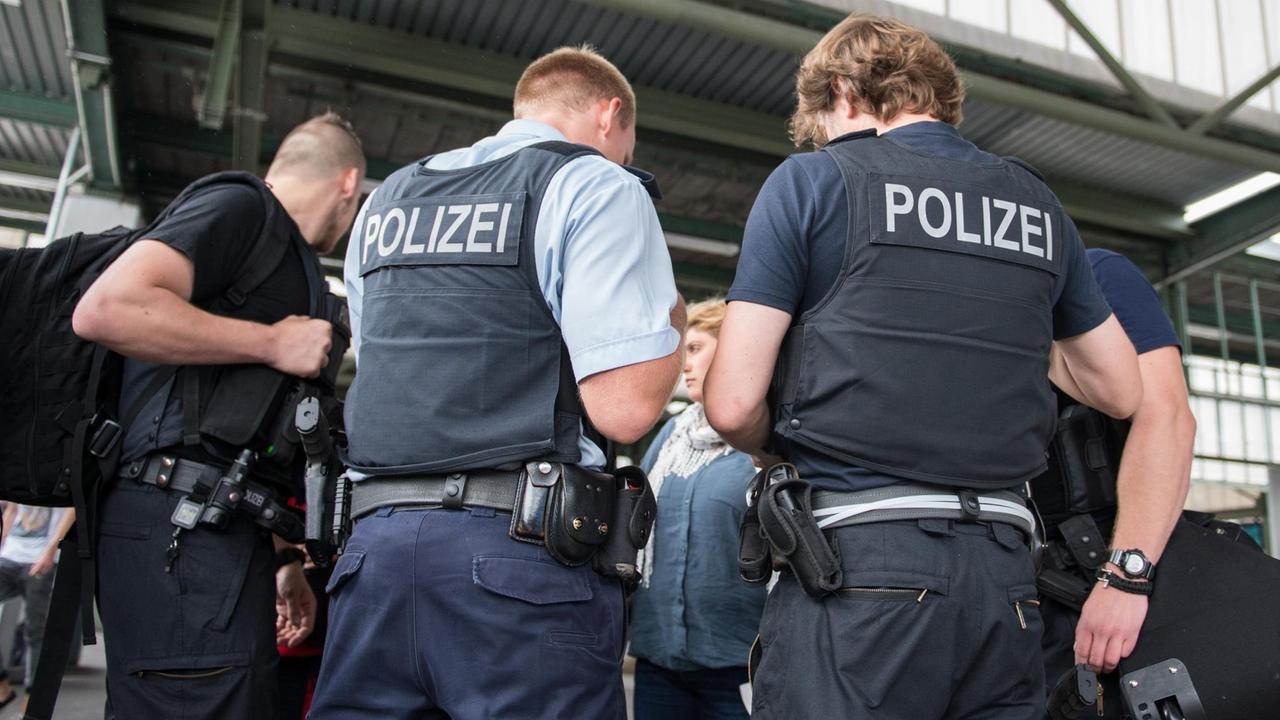 Beamte der Bundespolizei sprechen am Hauptbahnhof in Stuttgart mit neuankommenden Flüchtlingen.
