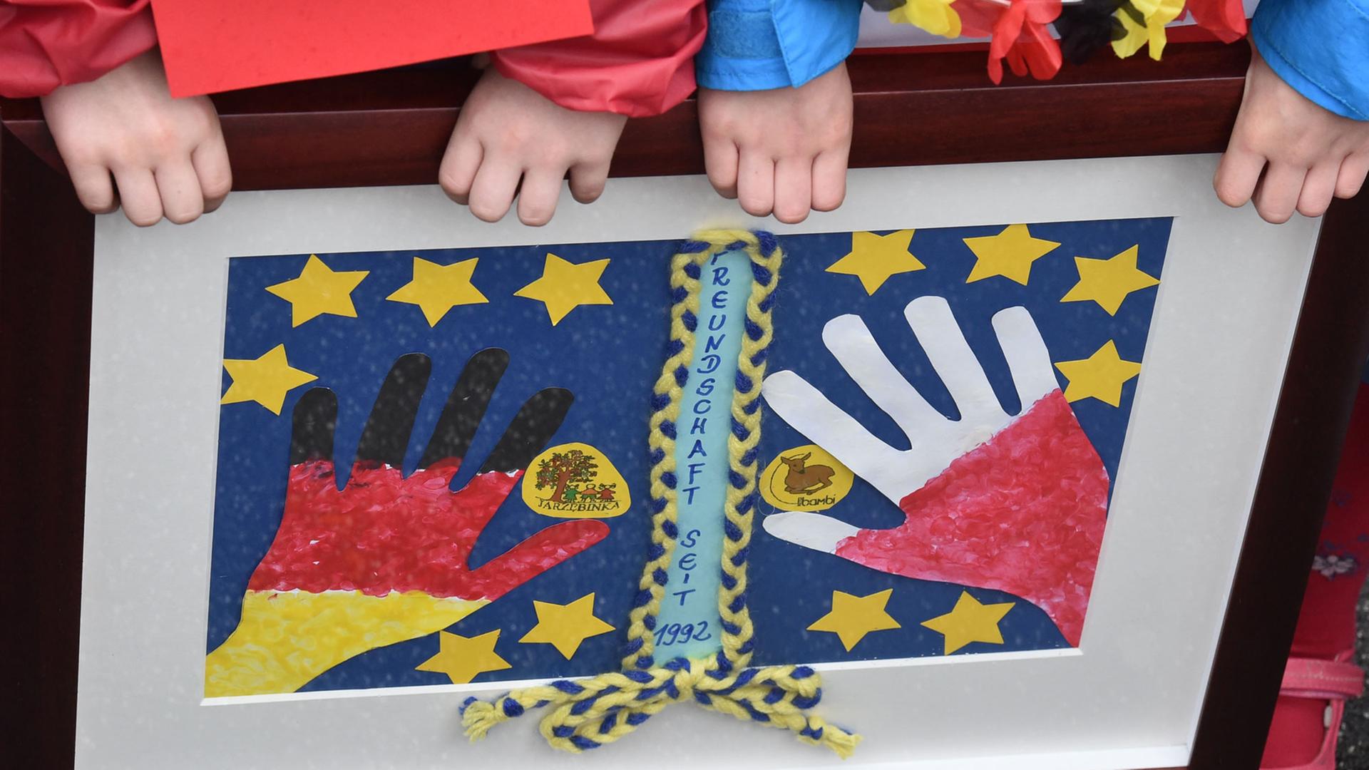 Anlässlich des Europafestes halten Kinder ein Bild mit Händen in den deutschen und polnischen Farben in Frankfurt an der Oder hoch.