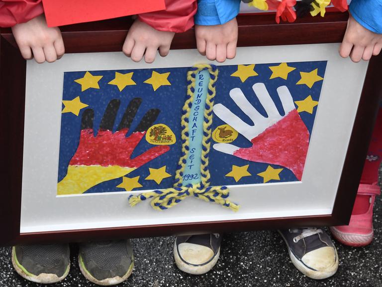 Anlässlich des Europafestes halten Kinder ein Bild mit Händen in den deutschen und polnischen Farben in Frankfurt an der Oder hoch.
