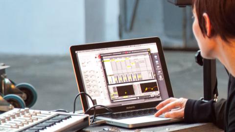 Eine Frau stellt die Sound-Software auf ihrem MacBook-Computer ein.