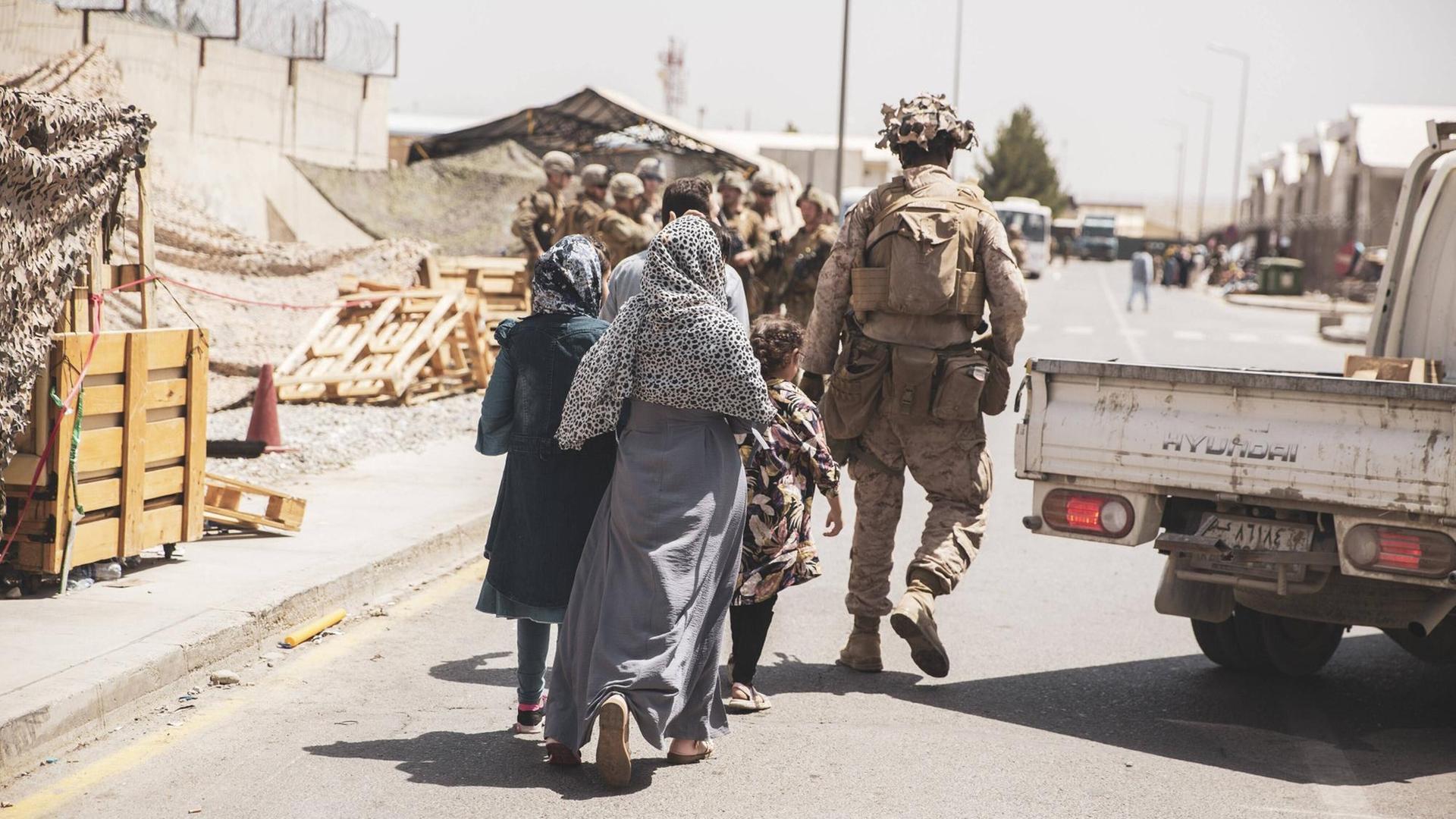 US-Soldaten begleiten eine afghanische Familie am Flughafen Kabul.