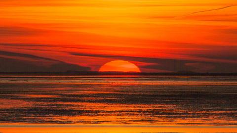 Sonnenuntergang über dem Wattenmeer in den Farben Rot und Orange