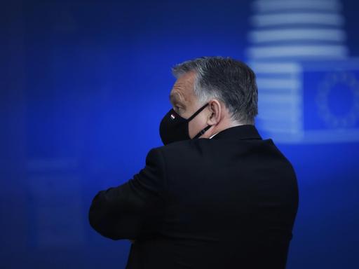 Ungarns Premier Viktor Orbán nach einem EU-Gipfel im Dezember 2020; er steht alleine mit Gesichtsmaske und wendet sich von der Kamera ab