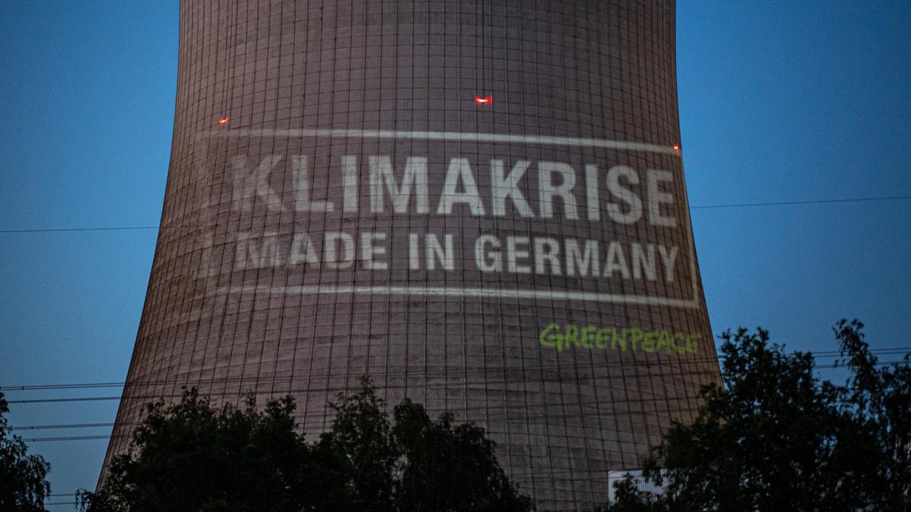 Aktivisten von Greenpeace projektieren bei einer Protestaktion vor dem Gelände des Kohlekraftwerks Datteln 4 den Schriftzug: "Klimakrise - Made in Germany" auf den Kühlturm. 