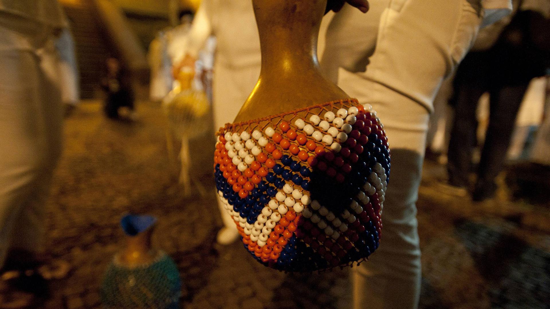 Eine Person hält eine Rassel bei einer Veranstaltung in Bixiga in Sao Paulo.