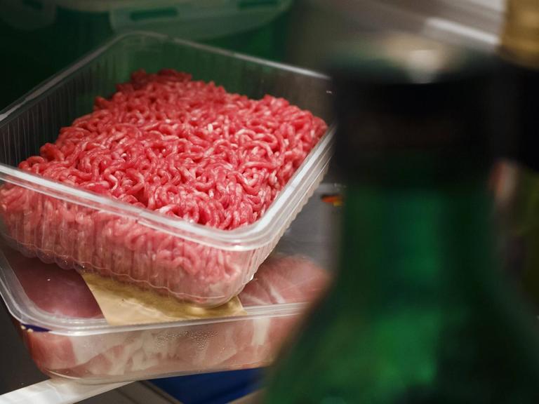 Billigfleisch: Hackfleisch aus dem Supermarkt in einer Plastikverpackung steht in einem Kühlschrank zwiachen anderen Lebensmittelverpackungen.