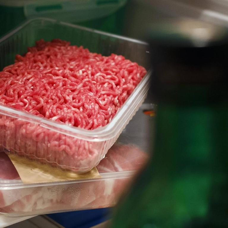 Billigfleisch: Hackfleisch aus dem Supermarkt in einer Plastikverpackung steht in einem Kühlschrank zwiachen anderen Lebensmittelverpackungen.