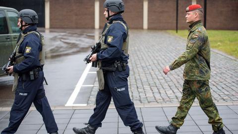 Zwei Polizisten der operative Einheit OpE und ein Bundeswehrsoldat marschieren am 08.03.2017 bei der ersten gemeinsamen Übung von Polizei und Bundeswehr, die sogenannte "Gemeinsame Terrorismus-Abwehr-Exercise" (GETEX), in Saarbrücken (Saarland) auf dem Gelände des Landespolizeipräsidiums.