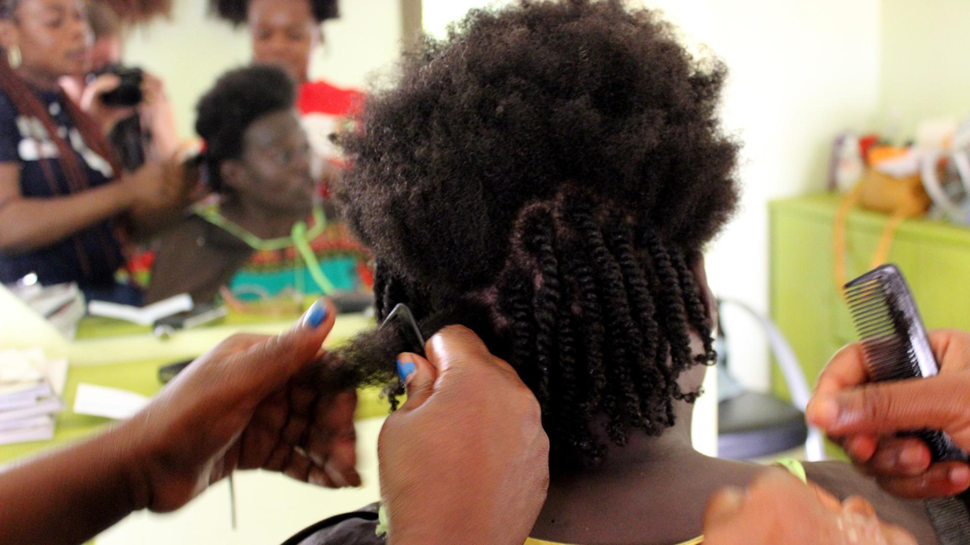 Eine Frau lässt sich beim Friseur sogenannte Twists machen.
