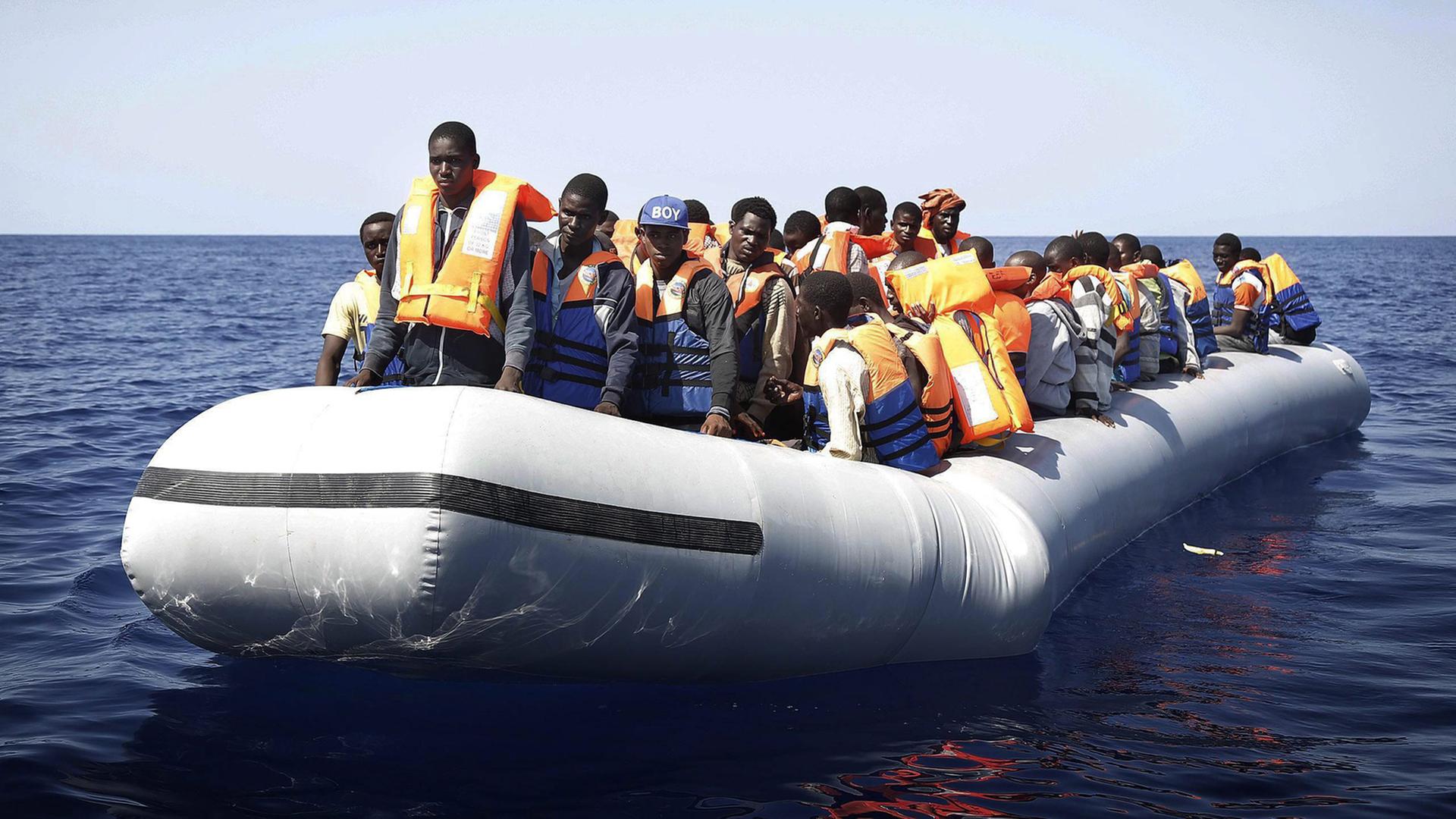 Ein Boot mit Dutzenden Flüchtlingen aus Afrika auf offener See.