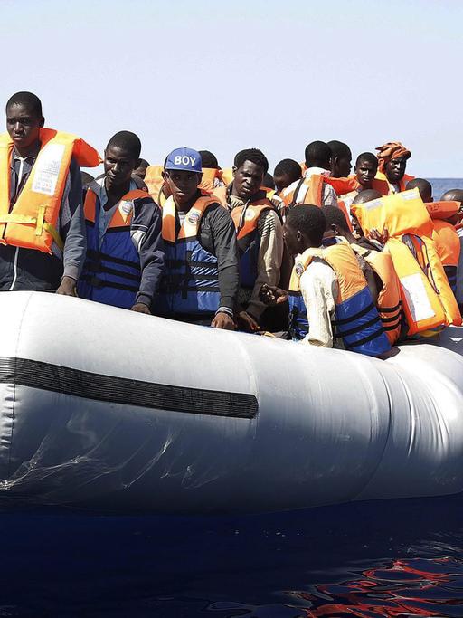 Ein Boot mit Dutzenden Flüchtlingen aus Afrika auf offener See.