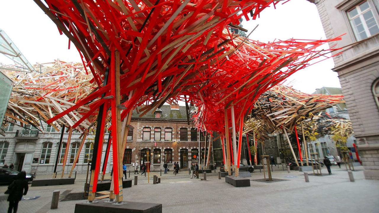 Holzkonstruktion "The Passenger" im belgischen Mons. Vor allem rote Holzbalken als Dach über Fußgängerzone montiert.