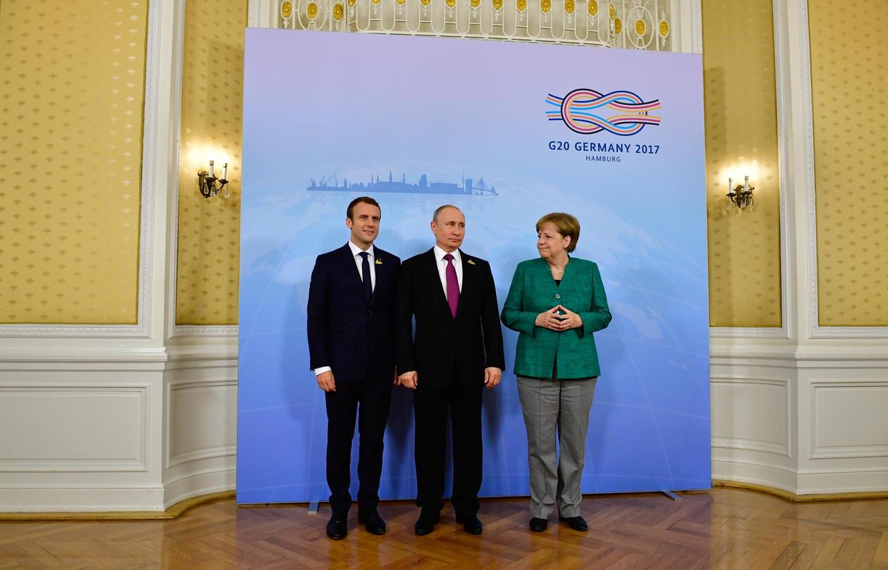 Der Präsident von Frankreich, Emmanuel Macron (l-r), der Präsident von Russland, Wladimir Putin, und Bundeskanzlerin Angela Merkel stehen am 08.07.2016 im Hamburger Hotel Atlantik