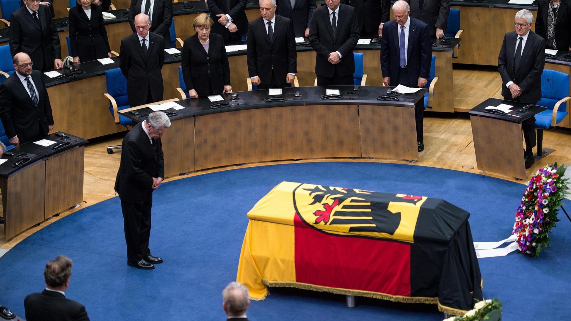 Bundespräsident Gauck verneigt sich vor dem mit einer Deutschlandflagge bedeckten Sarg von Hans-Dietrich Genscher im Alten Plenarsaal in Bonn.