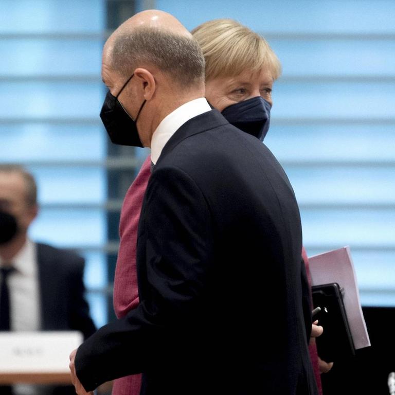 Bundesfinanzminister und Vizekanzler Olaf Scholz (SPD) geht in einer Kabinettsitzung an der Bundeskanzlerin Angela Merkel (CDU) vorbei.
