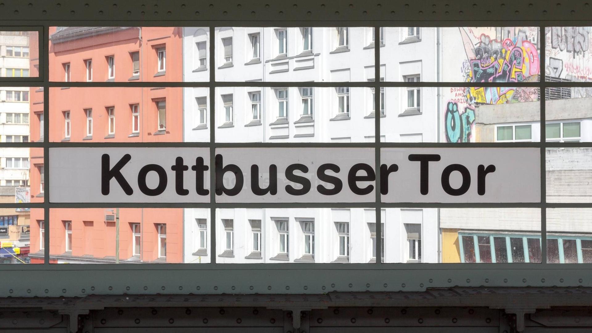 Das Foto zeigt den Bahnhof Kottbusser Tor - der Blick geht durch die Fenster des Bahnhofgebäudes nach draußen auf den Platz.