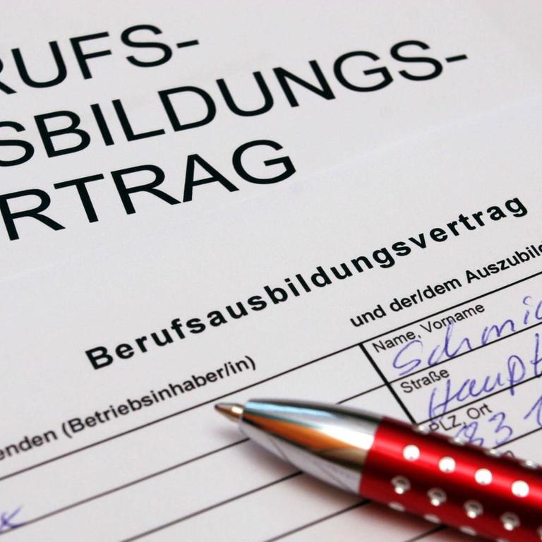 Ein Kugelschreiber liegt auf einem ausgefüllten Berufsausbildungsvertrag.