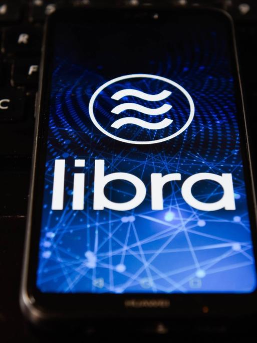 Auf dem Display eines Smartphone ist das Libra-Logo zu sehen.