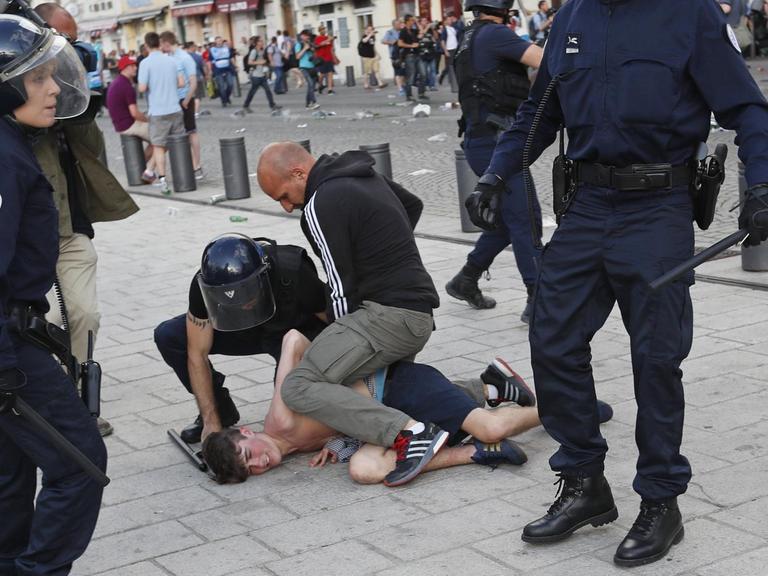 Ein Mann wird von französischen Sicherheitskräften in Marseille festgehalten.