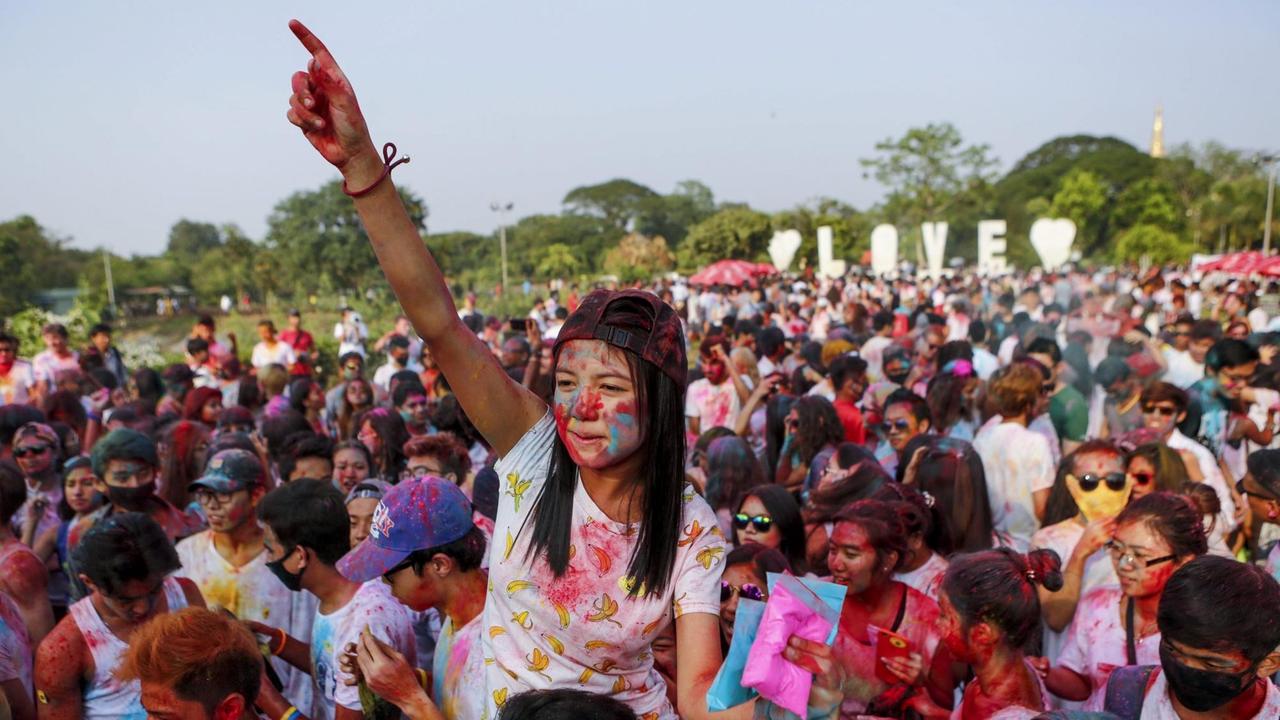 In Farben bedeckte Menschen während des ersten Holi-Festivals in Yangon, Myanmar am 26.März 2016. Tausende Menschen nahmen an diesem Event teil, welches vom indischen Holi-Fest inspiriert ist.