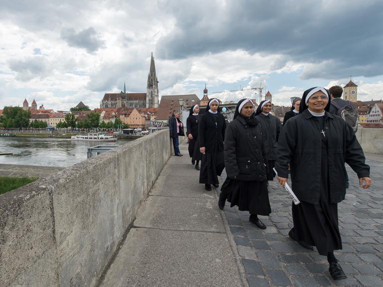 Ordensschwestern gehen am 31. Mai 2014 während des Katholikentags in Regensburg auf der Steinernen Brücke.