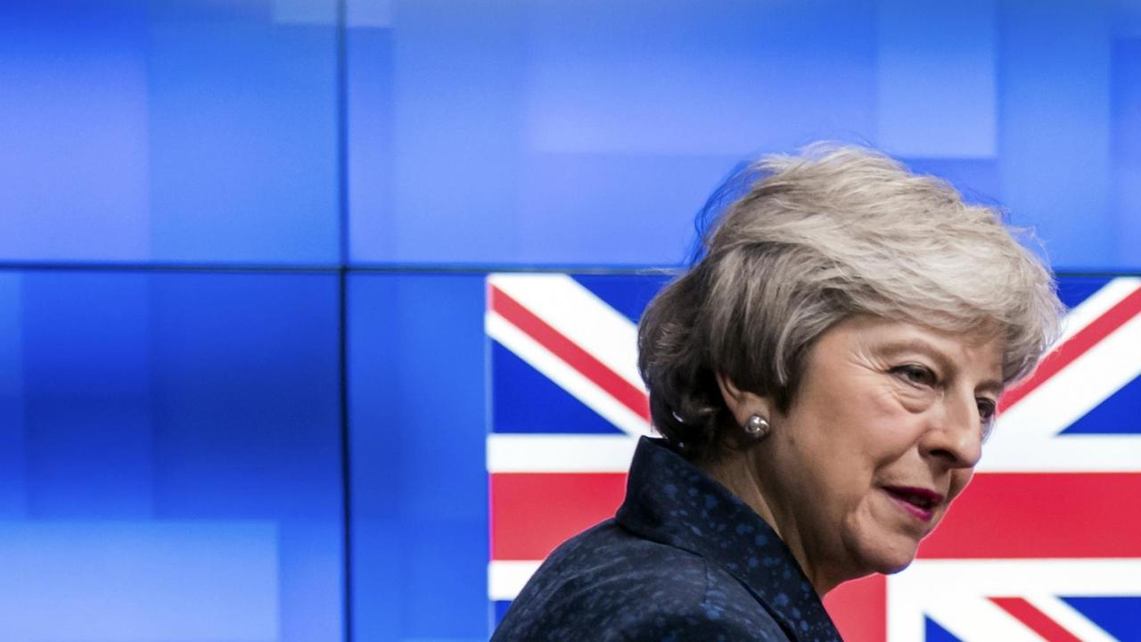 Die britische Premierministerin Theresa May blickt in Brüssel in eine Fotokamera.