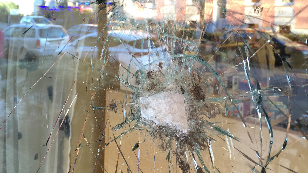 Die durch einen Anschlag zerstörte Schaufensterscheibe des Buchladens Leporello in Berlin-Neukölln.