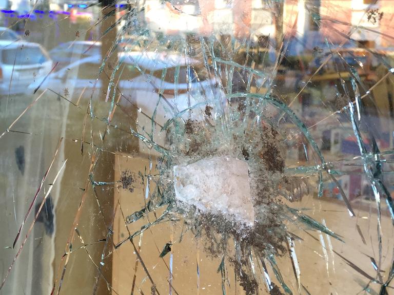 Die durch einen Anschlag zerstörte Schaufensterscheibe des Buchladens Leporello in Berlin-Neukölln.