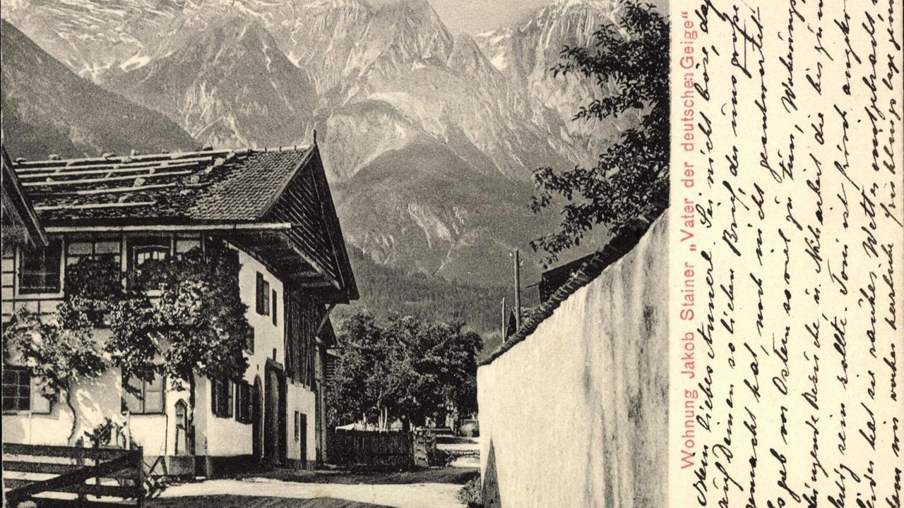 Postkarte von 1910, auf dem ein typischer Tiroler Hof vor Alpenpanorama zu sehen ist.