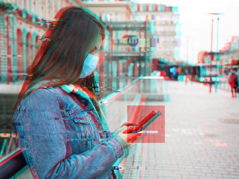 Eine Frau lehnt an einem Geländer und schaut auf ihr Handy. Das Bild ist schwarz/weiß mit einer Verschiebung von Rot- und Blauebene. Um das Smartphone ist ein rotes transparentes Quadrat.