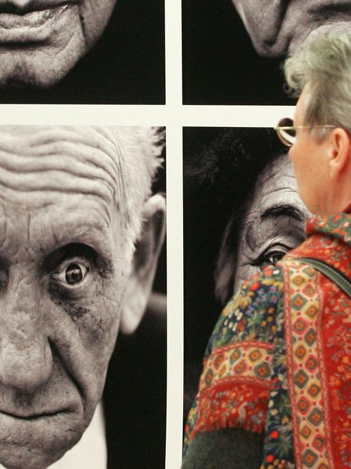 Eine Porträtserie der Fotografen Lucian Read und Martin Roemers betrachtet eine Besucherin der Ausstellung "World Press Photo des Jahres 2006" in Magdeburg.