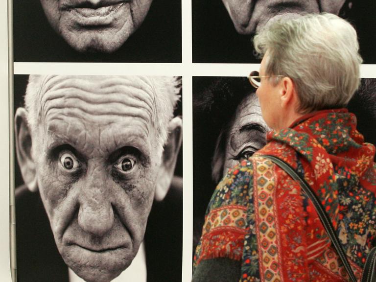 Eine Porträtserie der Fotografen Lucian Read und Martin Roemers betrachtet eine Besucherin der Ausstellung "World Press Photo des Jahres 2006" in Magdeburg.