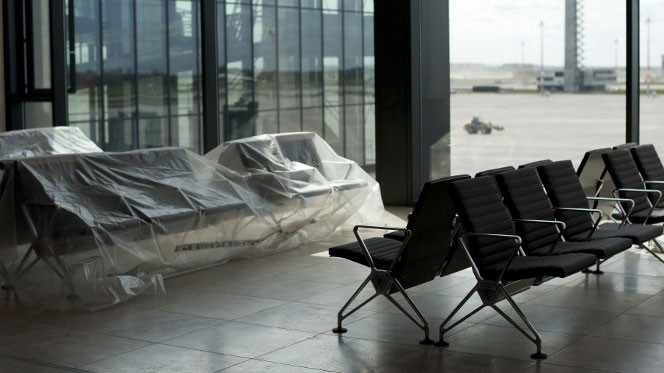Zwei Stuhlreihen, davon eine noch mit Plastikfolie abgedeckt, in der Wartehalle des neuen Hauptstadtflughafens Willy Brandt.