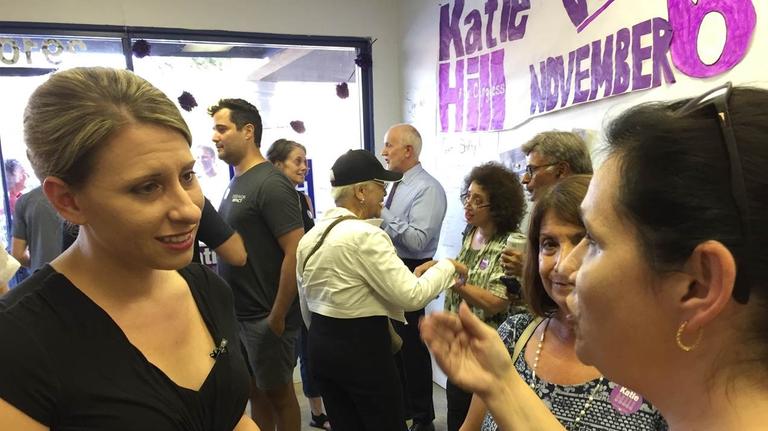 Katie Hill spricht mit einer Wahlkampfhelferin. Im Hintergrund unterhalten sich viele Leute.
