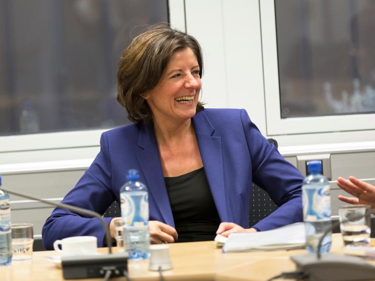 Malu Dreyer, die Ministerpräsidentin von Rheinland-Pfalz sitzt an einem Tisch.