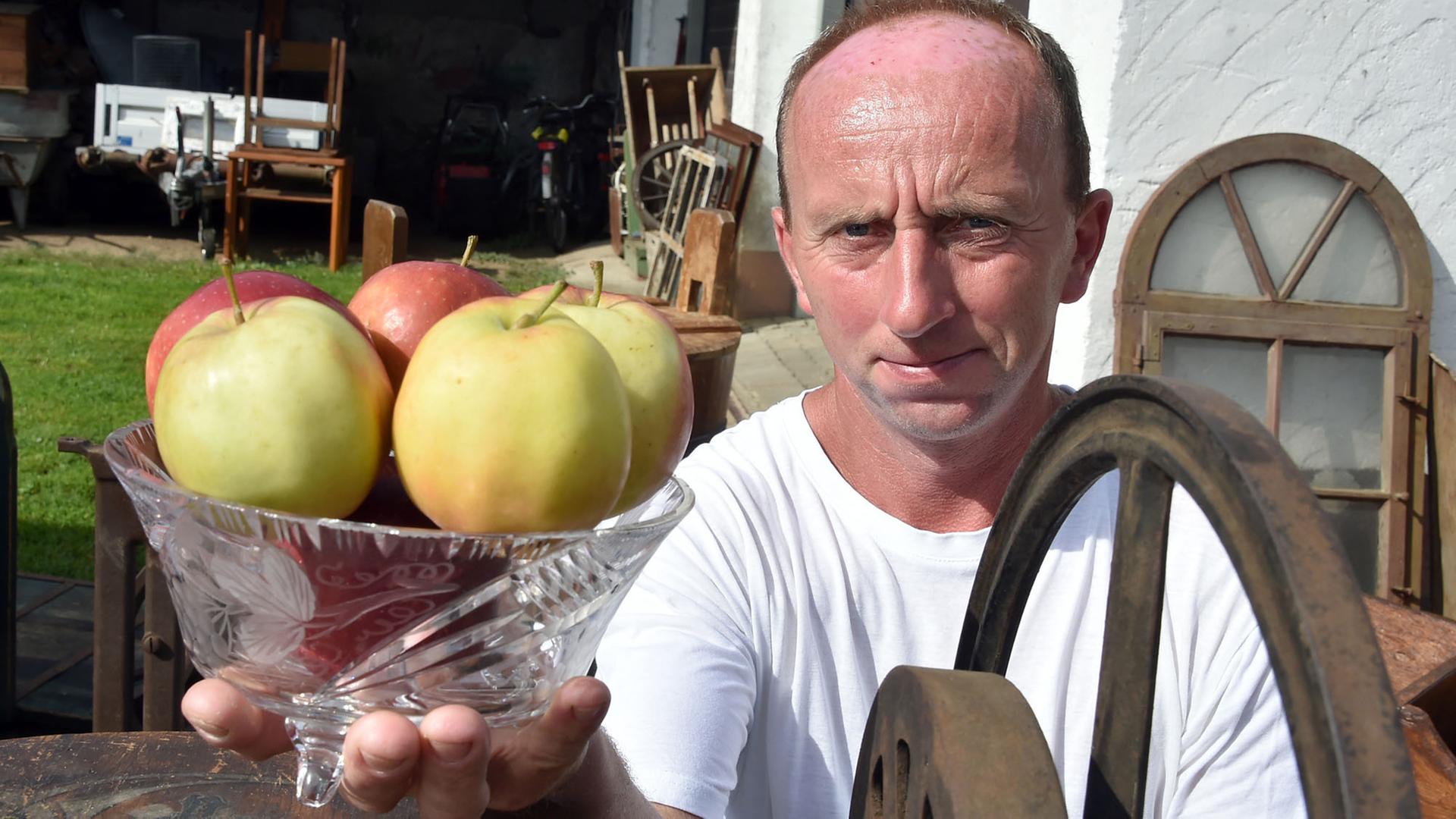 ARCHIV - Marko Steidel präsentiert am 18.08.2017 in Groß Drewitz (Brandenburg) eine Schale mit Äpfeln.