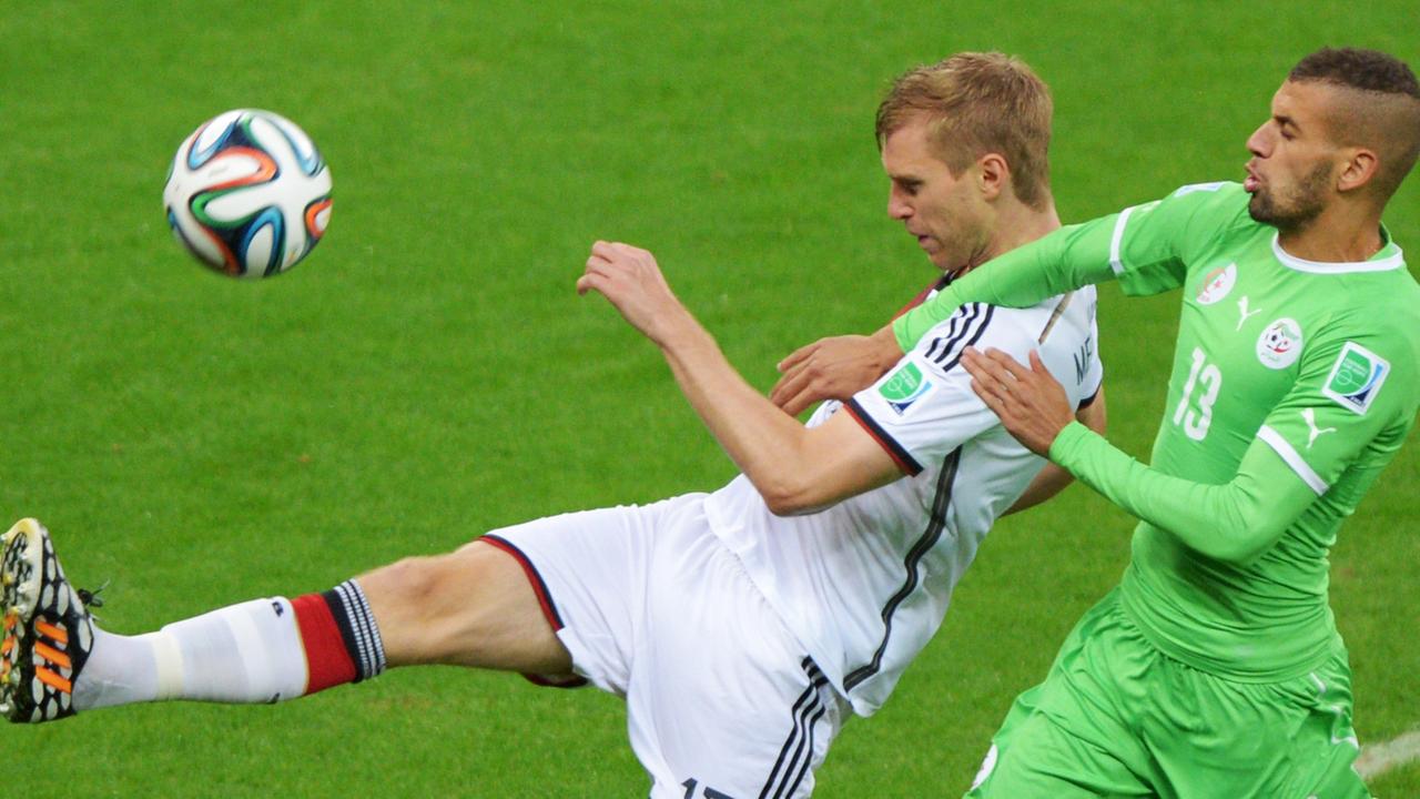 Der deutsche Nationalspieler Per Mertesacker im Zweikampf mit Algeriens Islam Slimani.