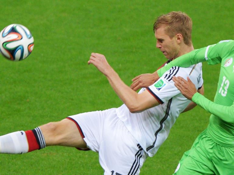 Der deutsche Nationalspieler Per Mertesacker im Zweikampf mit Algeriens Islam Slimani.
