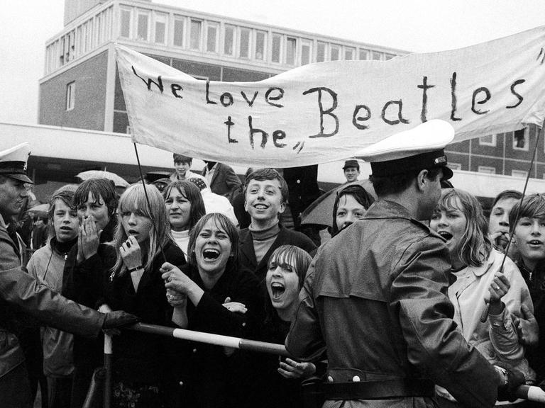 Beatlesfans tragen mit der Aufschrift "We love the Beatles".