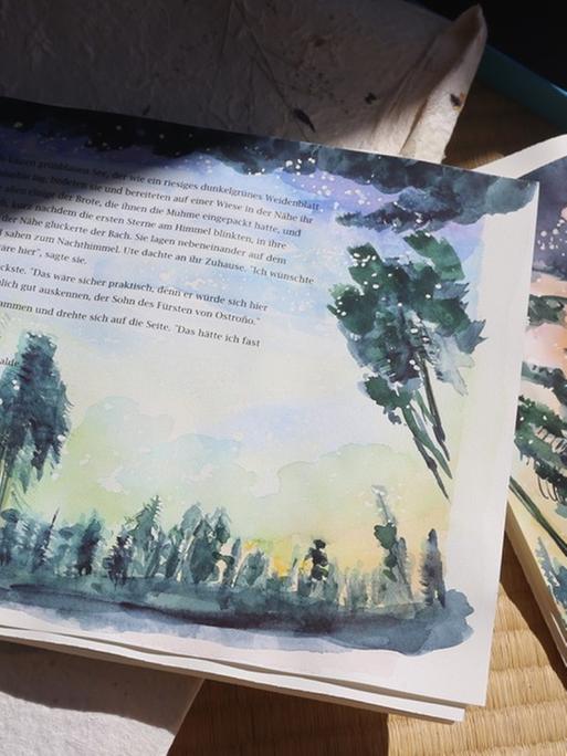 Zwei Seiten mit Original-Illustrationen aus einem Kinderbuch liegen im Halbschatten