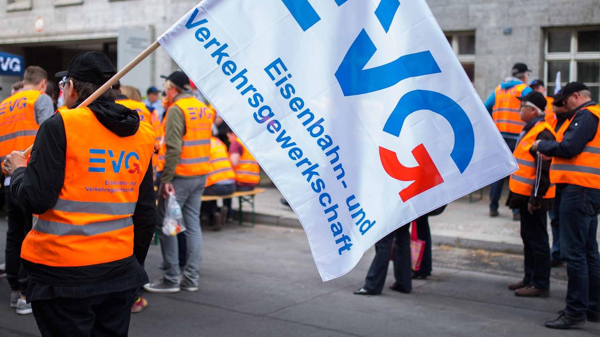 Mitglieder der Eisenbahn- und Verkehrsgewerkschaft (EVG) nehmen am 21.05.2015 in Berlin an einer Kundgebung teil und schwenken Fahnen