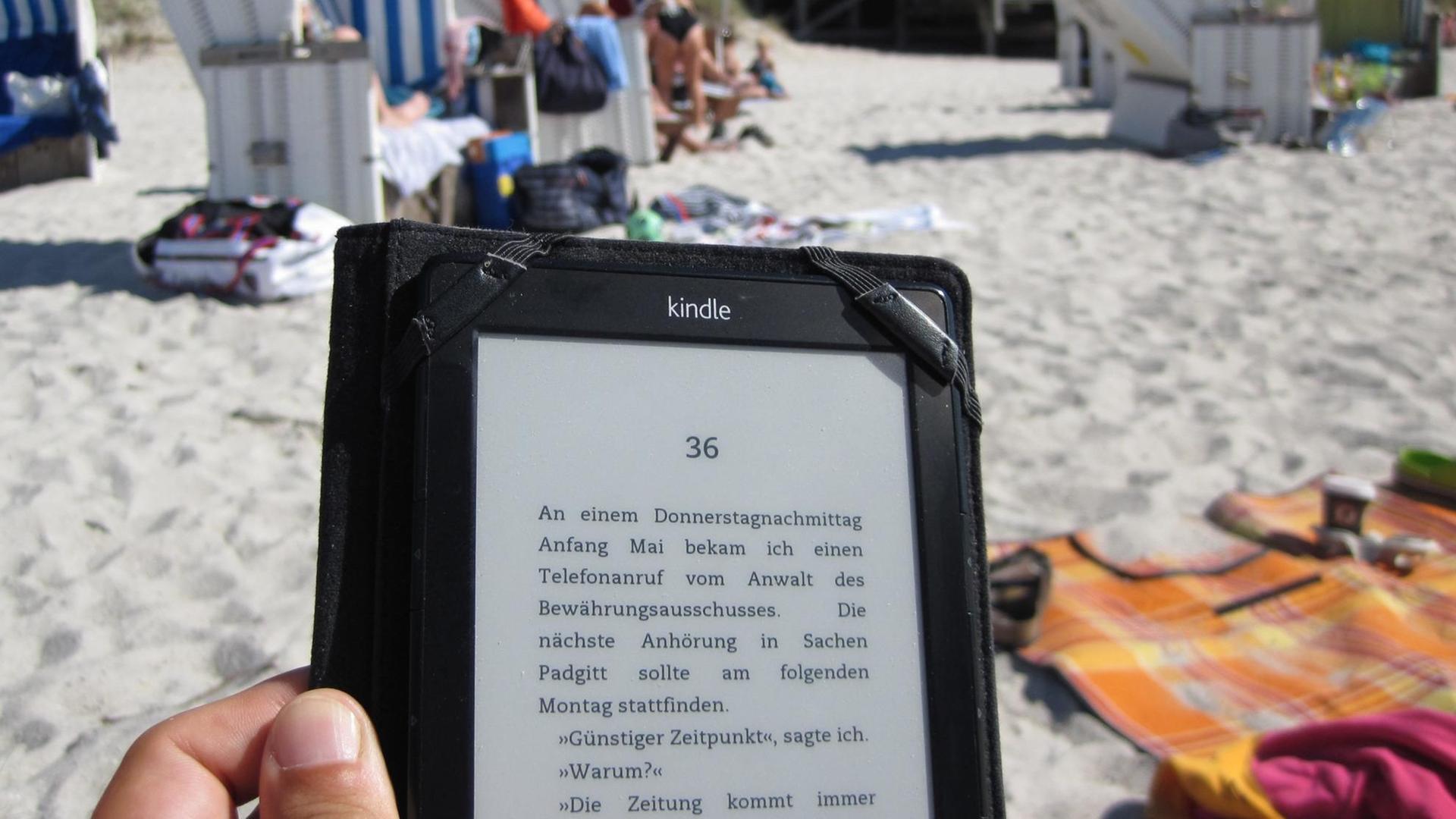 Ein E-Book wird an einem Strand benutzt