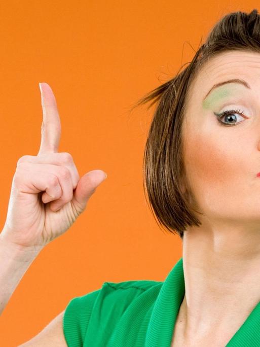 Junge Frau mit erhobenem Zeigefinger