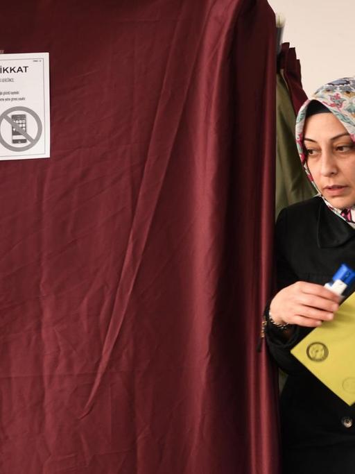 Eine Frau kommt in Istanbul aus einer Wahlkabine.