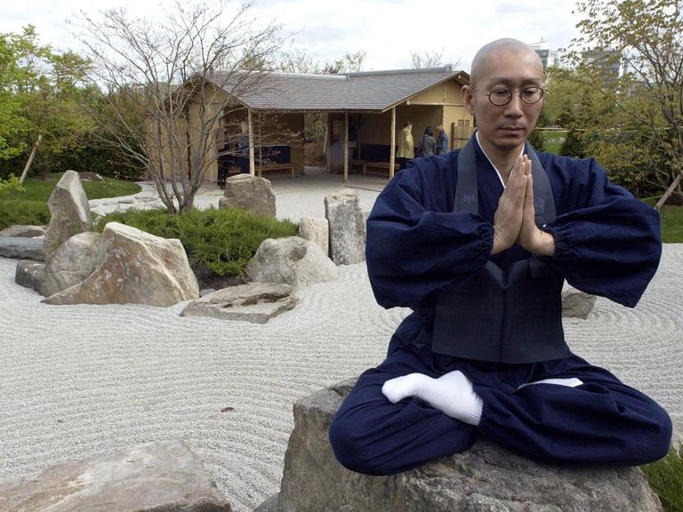 Der Zen-Priester und Gartenarchitekt Shunmyo Masuno meditiert im Japanischen Garten im Freizeitpark Berlin-Marzahn. Er hat hier die Oase der Ruhe geschaffen; Aufnahme vom April 2003