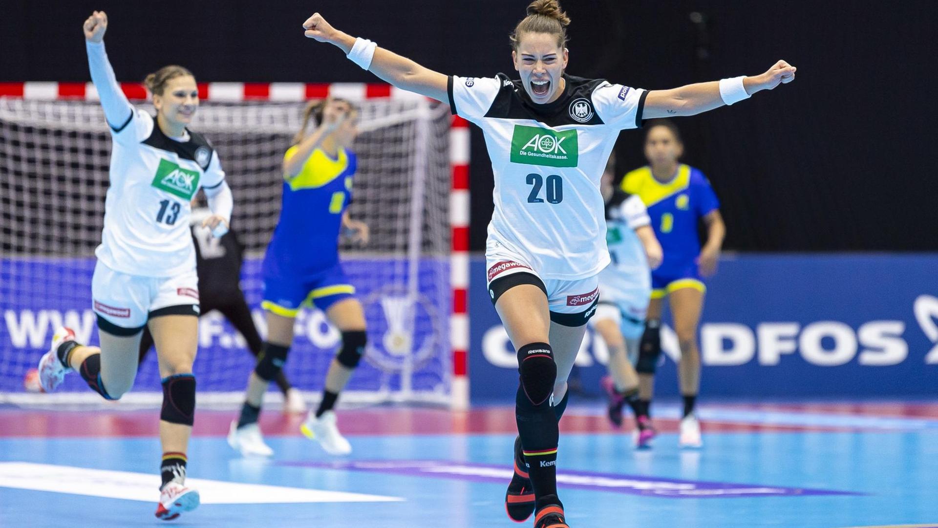 Deutschlands Handballspielerinnen Julia Behnke (vorne) und Emily Bölk (l) jubeln.