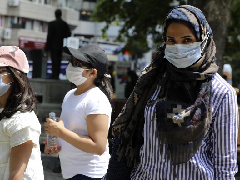 Ankara: Eine türkische Frau und Kinder tragen Mundschutz bei einem Spaziergang in einem öffentlichen Garten.