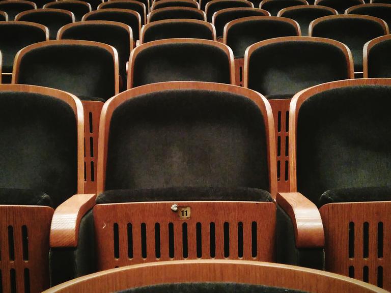 Eine leere Reihe von Theatersitzen. Das Verschwinden einer Schauspielerin während einer Vorstellung ist ein klarer Fall für Professor van Dusen.